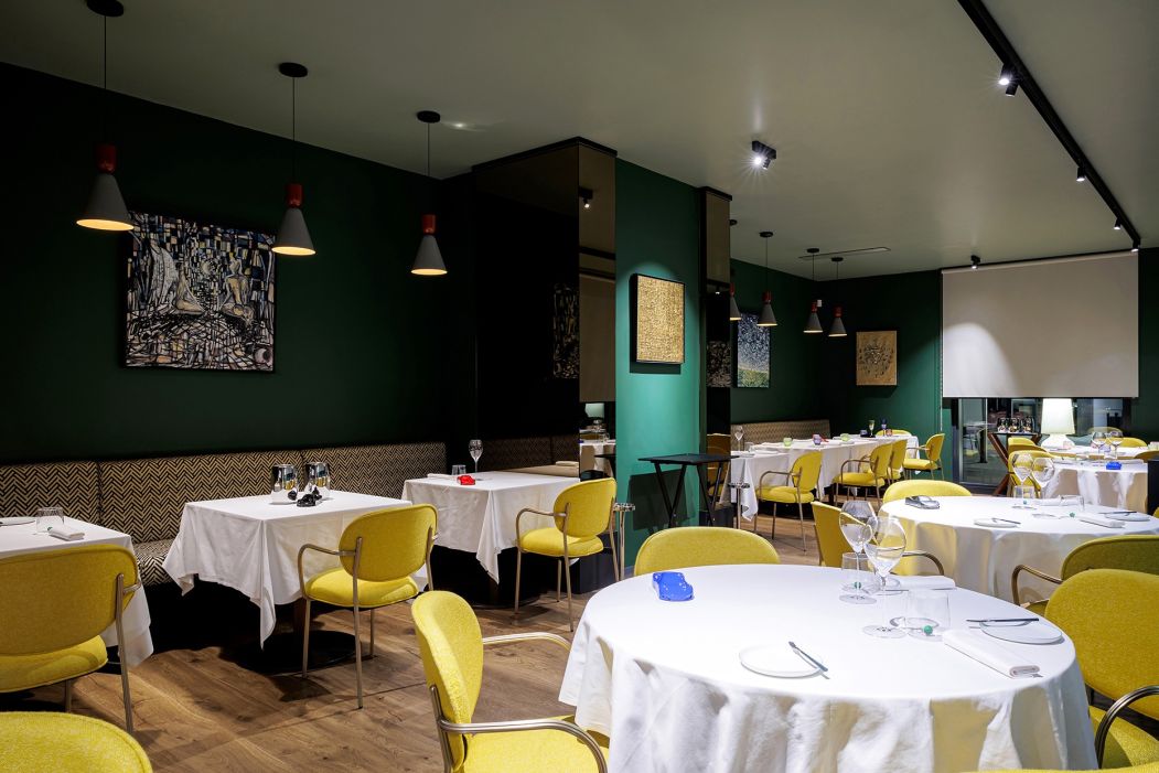 Sala bistrot con tavoli rotondi e sedie imbottite Pedrali